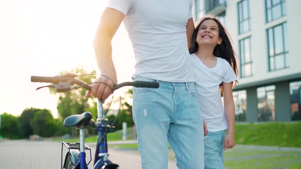 Dad and Daughter Walk Around Their Area After Cycling at Sunset