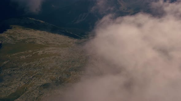 Flying through the clouds with the mountains below.