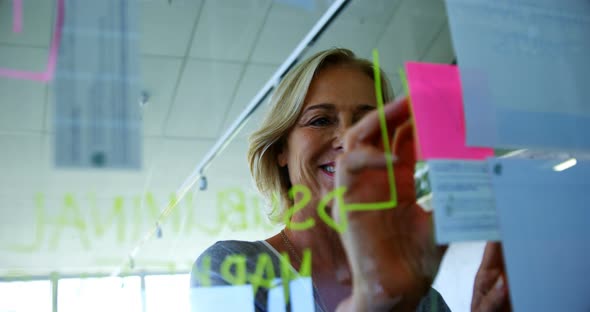 Female executive looking at sticky notes