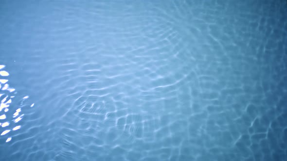 Slo-motion water rippling against blue background