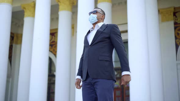 Portrait of Happy African American Businessman in Coronavirus Face Mask and Suit Making Victory