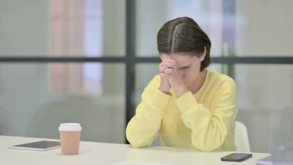 Upset Young Woman Feeling Worried While Sitting in Office