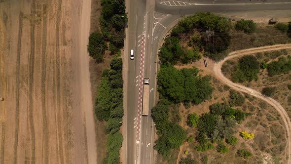 Truck loaded with Shipping Container driving on a rural highway, Aerial follow footage.