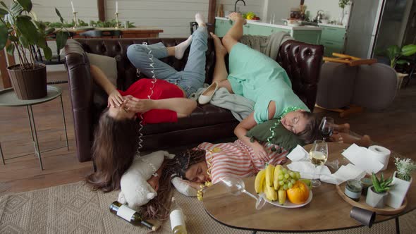 Diverse Female Friends Awaking to Terrible Hangover After Party Indoor