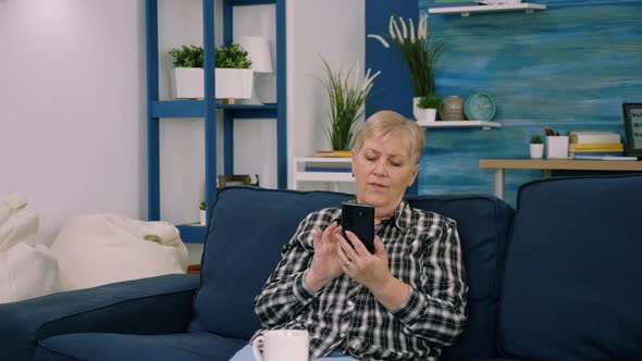 Overjoyed Middleaged Woman Sitting on Couch in Living Room