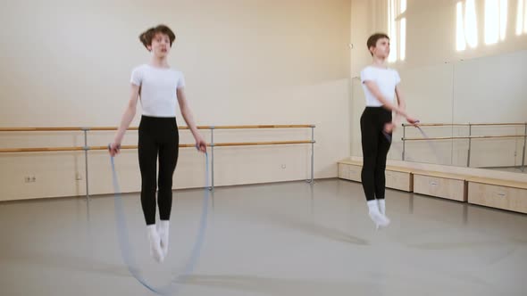 Boys Teenagers Jumping with Skipping Rope Doing Exercise in Ballet Dance School