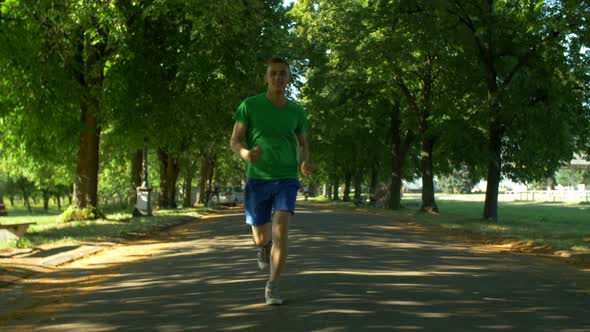 Athletic Young Man Running in Public Park