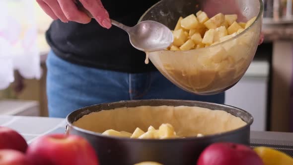 Apple Pie Preparation Series  Woman Pours Chopped Apples Into a Baking Dish