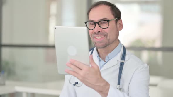 Middle Aged Doctor Doing Video Chat on Digital Tablet