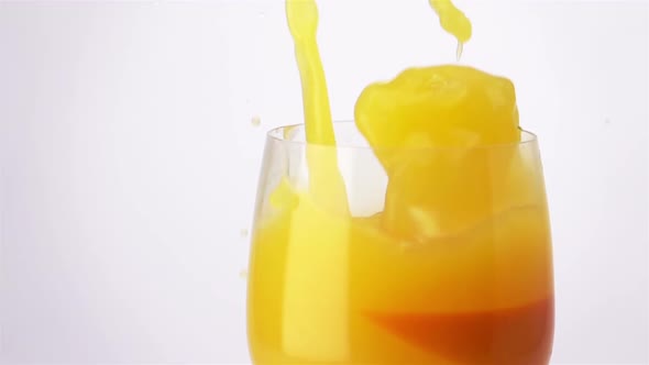 Slice of Orange Falling into a Glass of Orange Juice