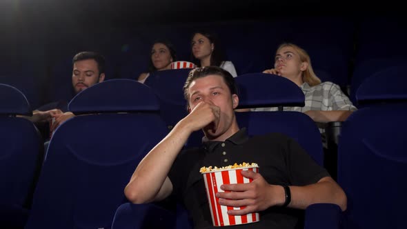 Handsome Man Falling Asleep During Movie at the Cinema