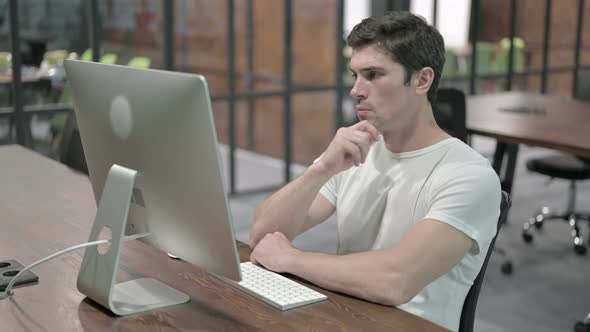 Pensive Senior Designer Thinking While Working on Computer