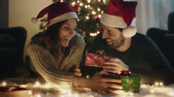 Boy and girl exchange Christmas gifts