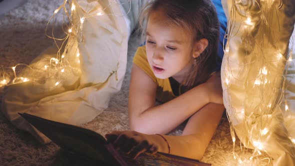 Family Bedtime Pretty Girl Reading Book in a Tent House at Night