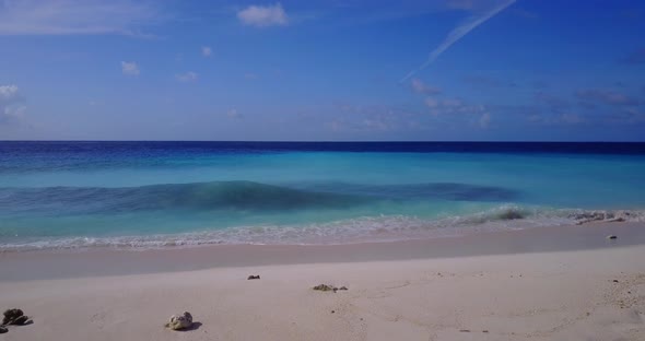 Wide above clean view of a sunshine white sandy paradise beach and aqua turquoise water background 