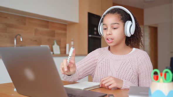 Young Teen Student Studying Online with Online Teacher on Laptop at Home