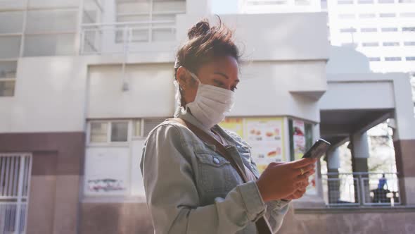 Mixed race woman wearing medical coronavirus mask on the street