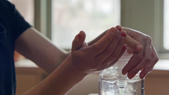 Corona pandemic - kids hands using hand sanitizer to prevent coronavirus spread