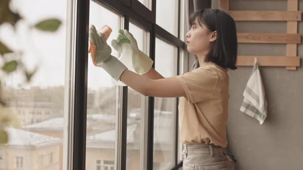 Asian Woman Cleaning Windows at Home