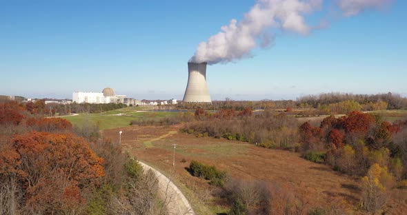 Nuclear power plant with steam going out. Drone videoing up.