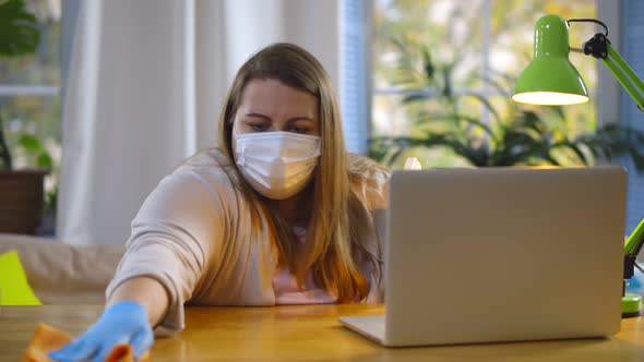 Obese Woman in Safety Mask Disinfecting Desk with Sanitizer Gel and Cloth Sitting at Home