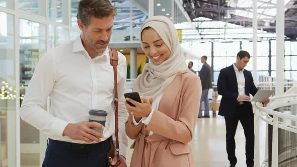 Business people using a smartphone in a conference foyer