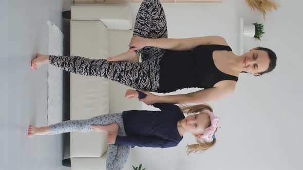 Woman with Little Daughter Doing Yoga Indoors