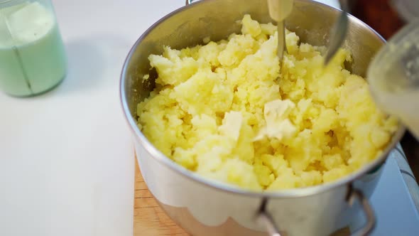 Female Hands Prepare Mashed Potatoes Mix Mashed Boiled Potatoes with a Crush and Add Pieces of