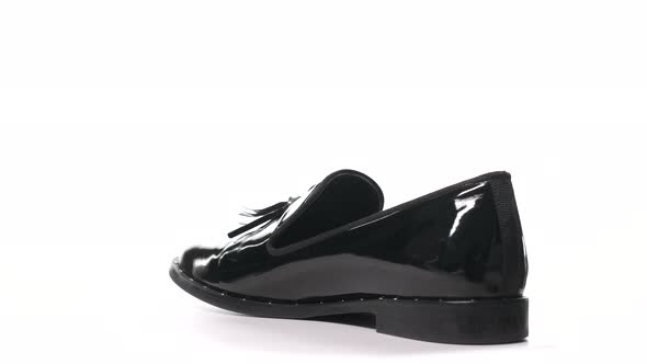 Black Patent Woman's Shoe Revolves on a White Background