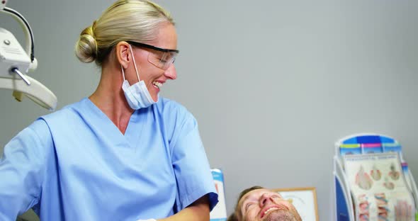 Female dentist giving high five to male patient