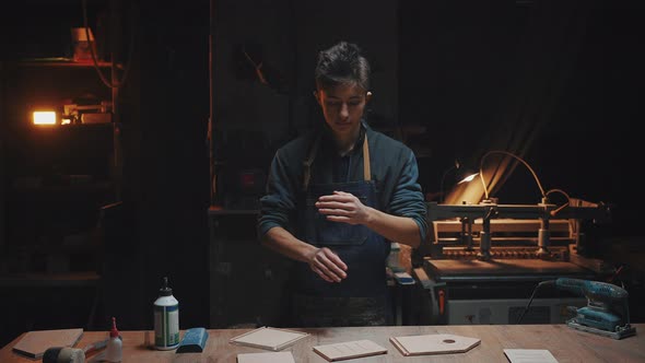 Confident Young Craftsman Stands Near a Work Table in a Carpentry Workshop