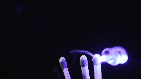 Slow motion of blue laser pointer lighting a match