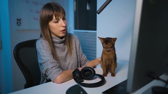 Young Female Blogger Petting Her Abyssinian Cat and Talking on Camera