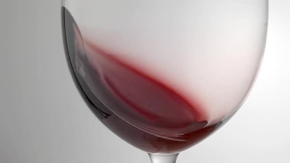 Slow Motion Shot of Red Wine Being Swirled Around Glass