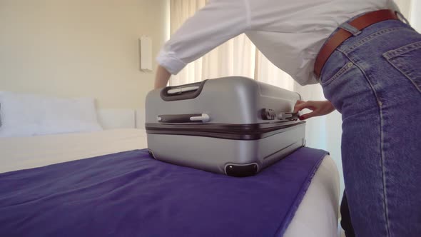 a woman in a Santa Claus hat puts things out of a suitcase after a vacation