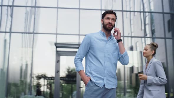 Handsome Man Speaking Cellphone at Glass Office Building