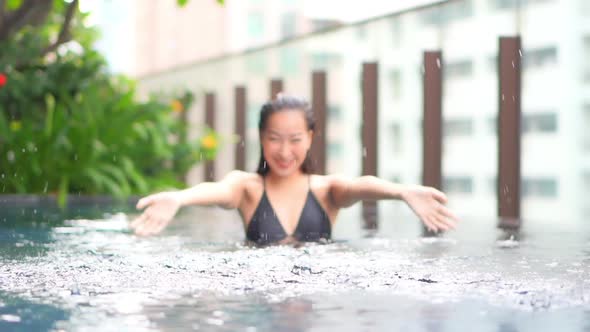 Young asian woman enjoy around outdoor swimming pool for leisure