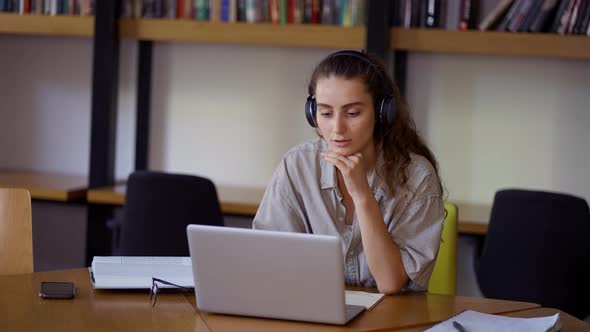 Young Woman Study at Distant Learning at Library with Laptop