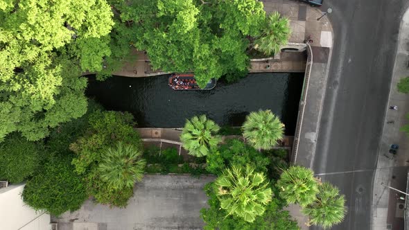 San Pedro Creek and Arneson River flow through downtown San Antonio River Walk park. Barge full of t