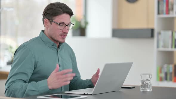 Middle Aged Man Speaking on Video Call on Laptop