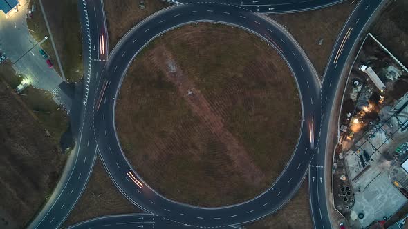 Aerial View of Road Roundabout Intersection with Fast Moving Heavy Traffic at Night