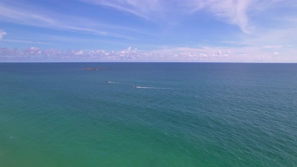 Aerial shot of open ocean Blue sky and horizon. Drone flying follow Fishing boats in the andaman sea