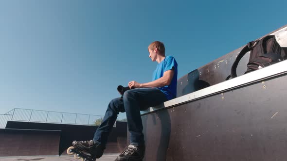 Man In Skate Park Putting On Protection