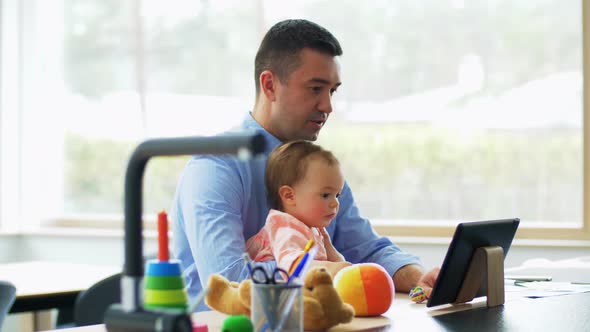 Father with Baby Working on Tablet Pc at Home