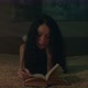 Woman Flipping Page In A Dimly Lit Room. - VideoHive Item for Sale