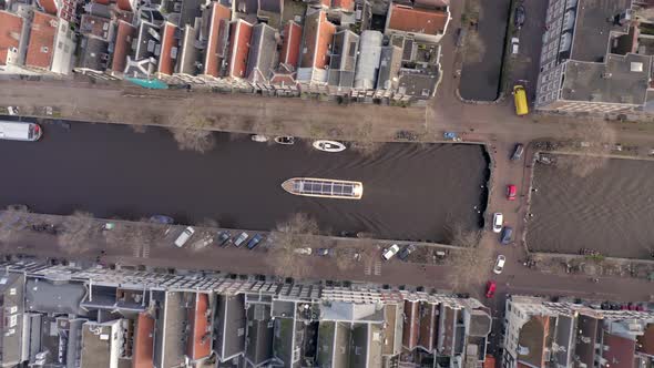 Canal Boat Tour in Amsterdam Amongst Riverside Houses Bird's Eye View