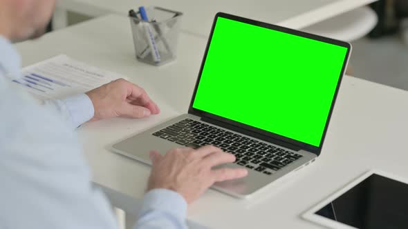 Middle Aged Man Using Laptop with Green Chroma Screen