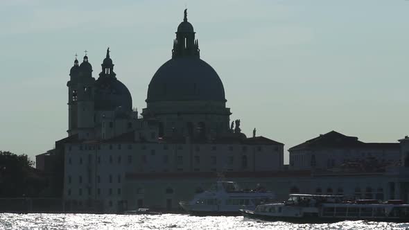 Skyline formed by monumental cathedral by waterfront with ferries, slow motion