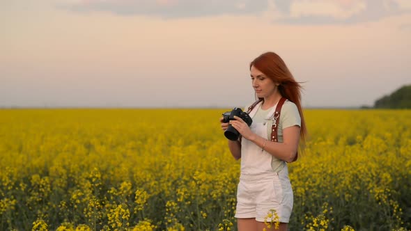 Young Woman Photographer in a Blooming Field