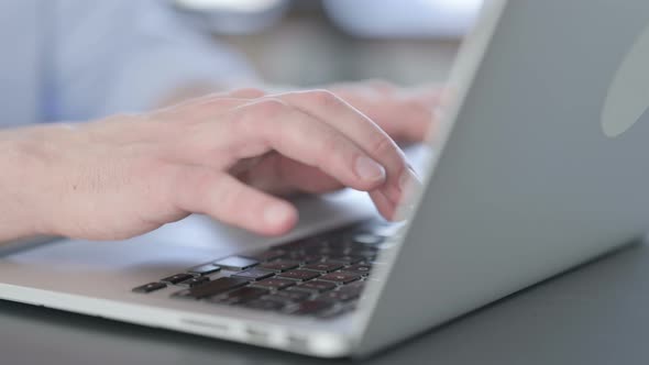 Close Up of Hands of Man in Glasses Typing on Laptop